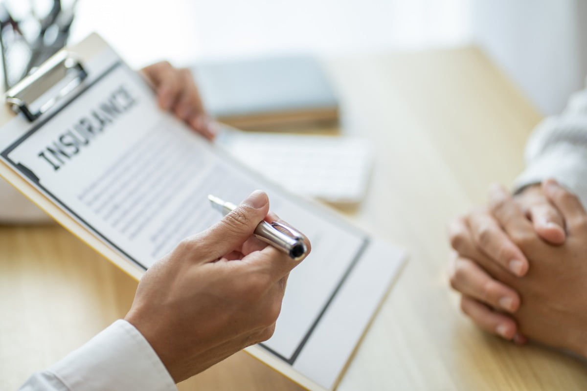 Insurance adjuster showing a client something on a clipboard